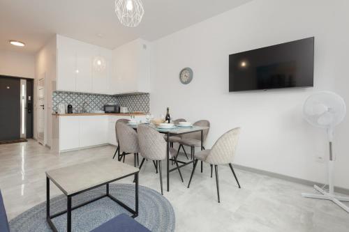 eine Küche und ein Esszimmer mit einem Tisch und Stühlen in der Unterkunft Lake House Sosnowy Las Mielno by Renters in Mielno