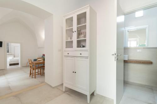 einen weißen Schrank in einer Küche mit einem Esszimmer in der Unterkunft Casa Vacanze L'angolo di Giadia in Matino