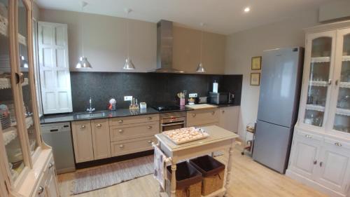 eine Küche mit einem Kühlschrank und einem Tisch darin in der Unterkunft Casa de Alicia Pontevedra Moraña Rías Baixas Casa Entera VT-PO-OOOO32 in Moraña