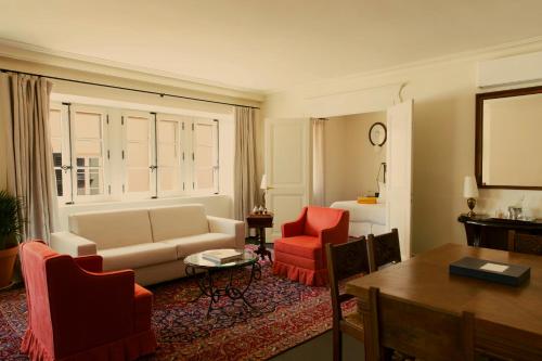 a living room with a couch and two red chairs at Hotel la Ponche in Saint-Tropez