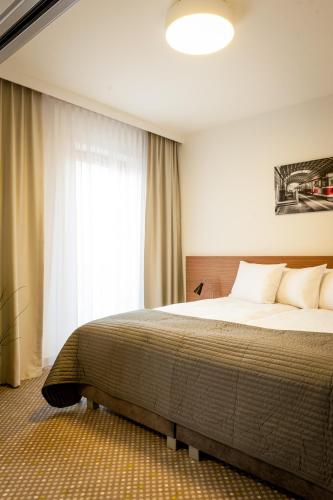a bedroom with a large bed and a window at Invite in Wrocław