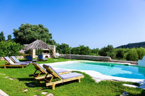 a pool with lounge chairs and a gazebo at Sonio Villas - Que Bella Collection in Plataniás