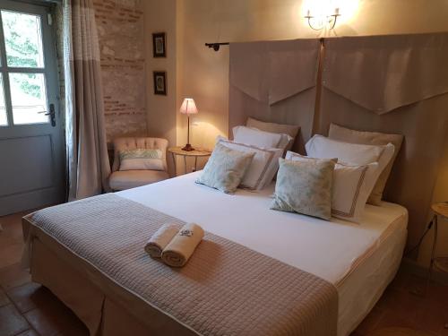 a bedroom with a large bed with two towels on it at Le clos du Mûrier in Fongrave