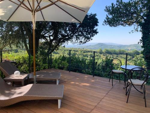 a wooden deck with a table and chairs and an umbrella at Relais Casamassima in Ponte Felcino