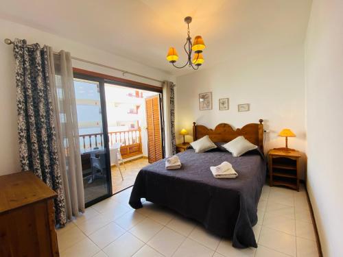 sypialnia z dużym łóżkiem i balkonem w obiekcie Mar Holiday Home w mieście Los Cristianos