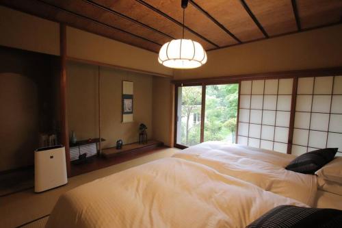 a bedroom with a large bed and a large window at Yamaguchi House Villa,Historic Japanese Room with Onsen in Miyanoshita