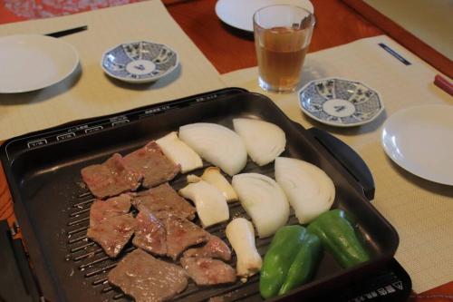 a pan with meat and vegetables on a table at Yamaguchi House Villa,Historic Japanese Room with Onsen in Miyanoshita