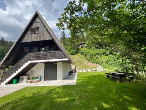 a house with a grassy yard with a picnic table at Our Forest House in Tržič