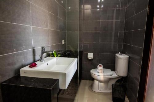 a bathroom with a sink and a toilet at Legian Bisma Suite in Seminyak