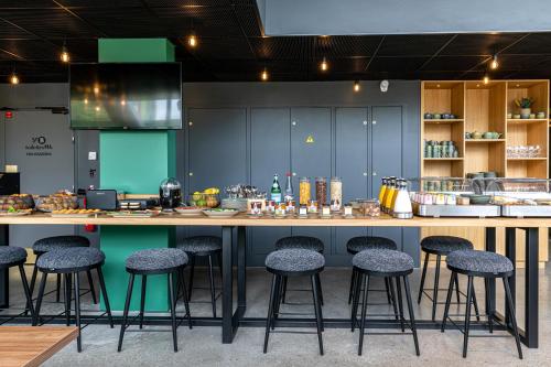 a kitchen with a counter with stools around it at Best Western M-Treize Paris Asnieres in Asnières-sur-Seine