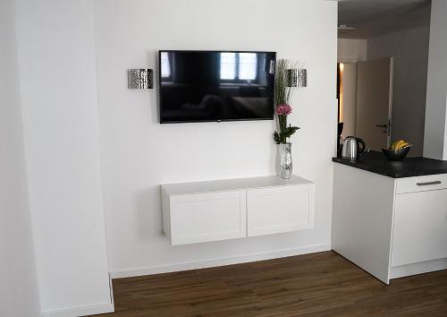 a white kitchen with a tv on the wall at Hänsel und Gretel in Dinkelsbühl