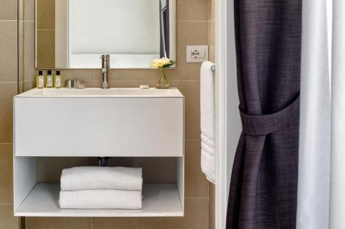 a bathroom with a white sink and a mirror at Hotel Astoria in Caorle