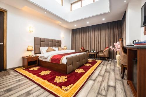 una camera con un grande letto con un tappeto rosso di THE FORTUNE RESORTS a Leh