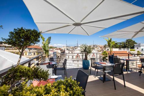 - un balcon avec une table, des chaises et un parasol dans l'établissement U-Visionary Roma Hotel, à Rome