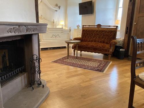 Una sala de estar con un sofá y una chimenea. en Napoleonzimmer / Studio, en Maring-Noviand