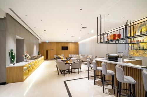a restaurant with tables and chairs and a bar at Golden Tulip Pontianak in Pontianak
