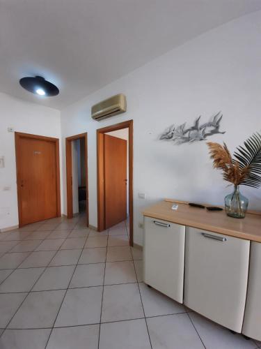 a room with a kitchen with a table and a counter at Hotel Villa del Mare Solanas in Solanas