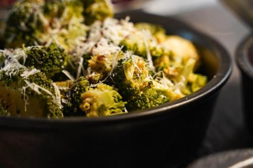a black bowl of broccoli with cheese on it at Comfort Hotel Kista in Stockholm
