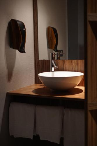 a bathroom with a white sink and a mirror at Hôtel Du Parc - Pirates in Chasseneuil-du-Poitou