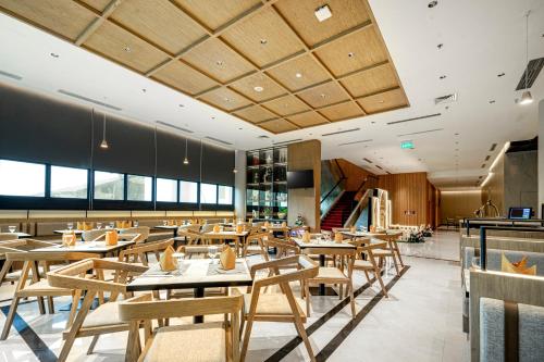 une salle à manger avec des tables et des chaises en bois dans l'établissement Golden Tulip Pontianak, à Pontianak