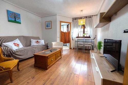 una sala de estar con un sofá y una mesa en El apartamentín de Lastres, en Lastres
