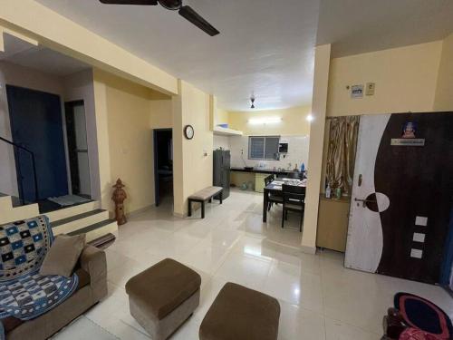 浦那的住宿－Swaradhya Hillside Villa 3BHK -AC - WiFi - SmartTV - Parking - Kitchenette - Near Lonavala，带沙发的大客厅和厨房