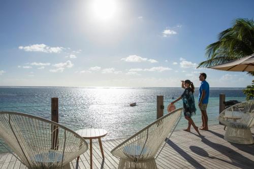 a man and a woman walking on a deck overlooking the ocean at Solana Beach Mauritius - Adults Only in Belle Mare