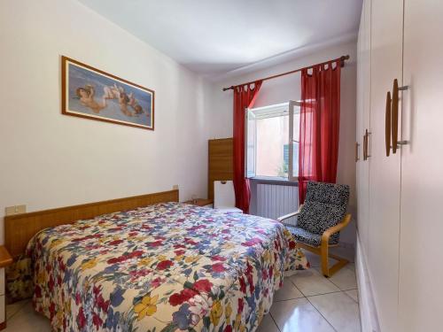 a bedroom with a bed and a chair and a window at Appartamento La Costarella in Marciana