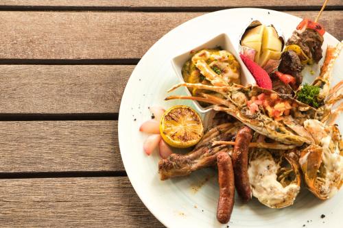 a plate of food with seafood on a wooden table at Solana Beach Mauritius - Adults Only in Belle Mare