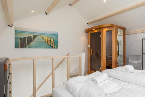Dos camas en una habitación con un cuadro en la pared. en Welcome in - Vakantiewoning met sauna en zonnig terras, en Biggekerke