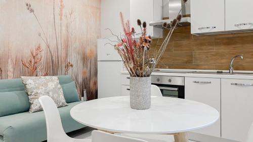 a kitchen with a white table and a vase with flowers at Appartamenti Natura e Terra Marmore in Terni