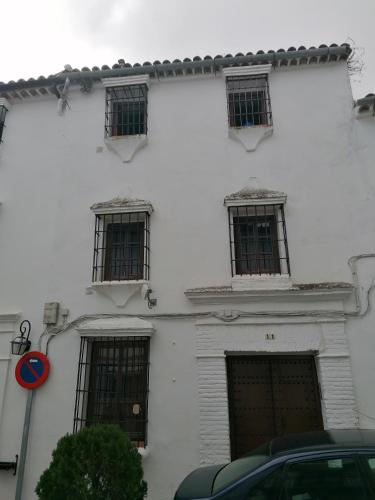 a white building with four windows on the side of it at Casas Las Piedras de Agua in Grazalema