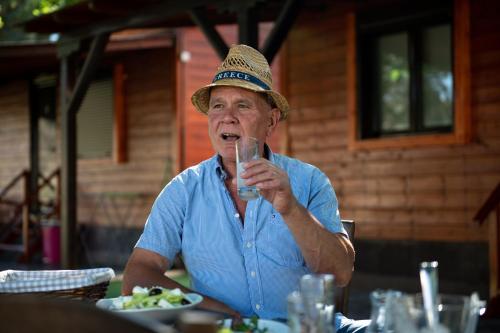 a man wearing a hat drinking from a glass at Marianna Studios in Kriaritsi