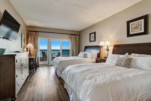 a hotel room with two beds and a balcony at 328 Sandcastle condo in Fernandina Beach