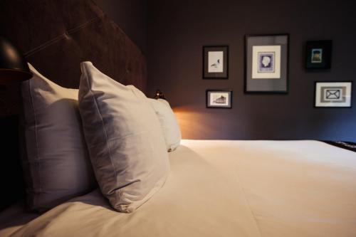 a bedroom with a bed with a white pillow at Post-Plaza Hotel & Grand Café in Leeuwarden