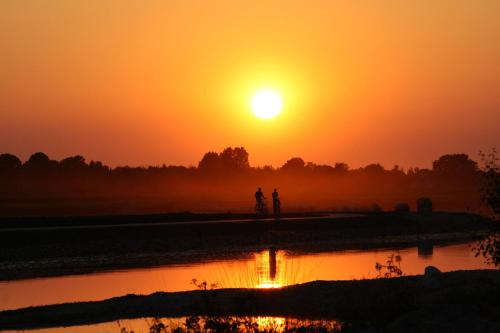 two people walking in front of a sunset at Wilmsboo in Nieuw-Schoonebeek