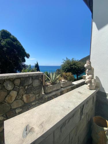 a stone retaining wall with a view of the ocean at Hotel Leopold in Moneglia