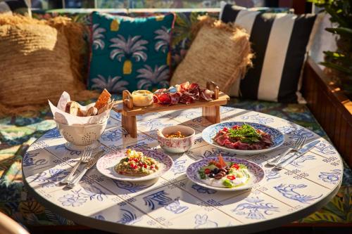 a table topped with plates of food on a couch at Mama Shelter Lisboa in Lisbon