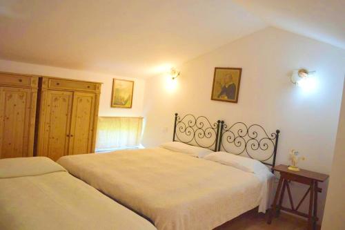 una camera con due letti con lenzuola bianche di One bedroom appartement with shared pool enclosed garden and wifi at Fabriano a Fabriano