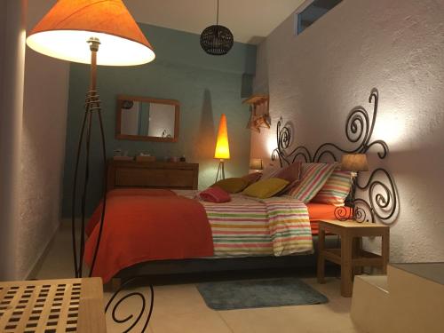 - une chambre avec un lit doté d'une lampe et d'un miroir dans l'établissement Gites Còr Causy OLEANDER, à Causses-et-Veyran