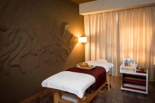 a bedroom with two twin beds and a table at Ramada by Wyndham Oradea in Oradea