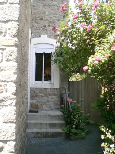 a stairway leading up to a window with pink flowers at Nouveau : maison à 50 m de la plage in Larmor-Plage