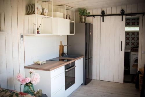  La cuisine est équipée de placards blancs et d'un réfrigérateur. dans l'établissement Kurkse KUUR, à Kurkse