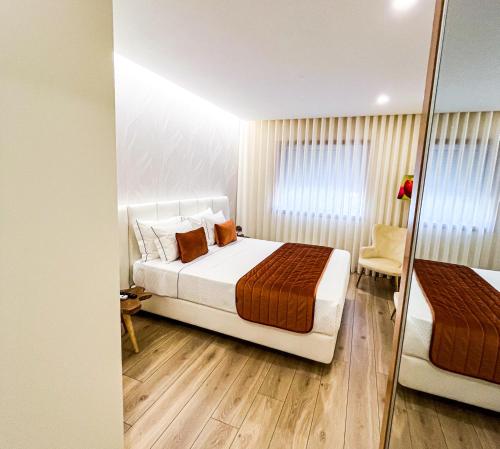 a bedroom with a bed and a mirror at Encosta do Monte in Ponte de Lima