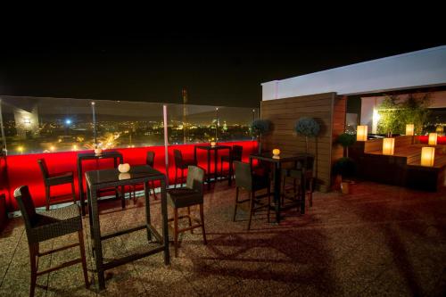 a group of tables and chairs on a rooftop at night at Ramada by Wyndham Oradea in Oradea