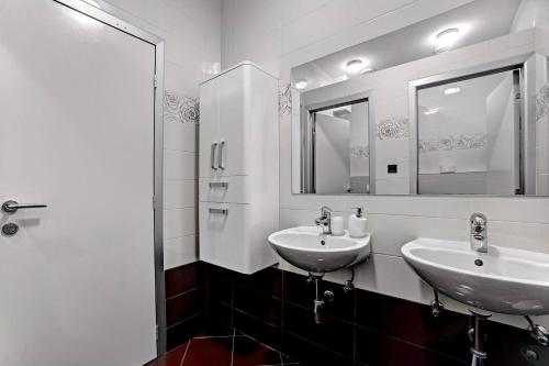 a bathroom with two sinks and two mirrors at Luxury Apartment Plavi Biser in Šibenik