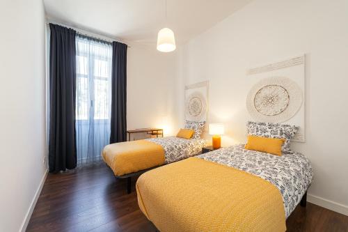 a room with two beds and a window at Foz Beach House - Rooftop & Sea view in Foz do Arelho