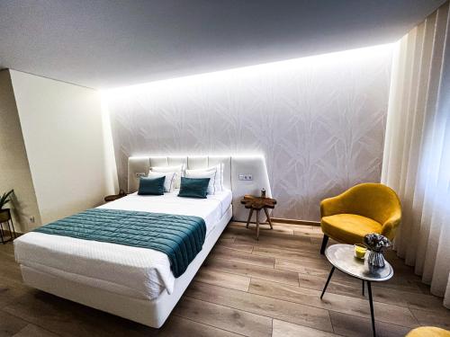 Habitación de hotel con cama y silla en Encosta do Monte, en Ponte de Lima
