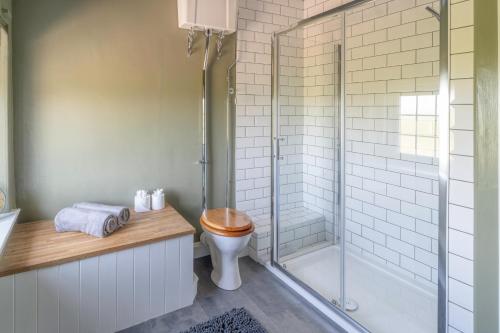 a bathroom with a toilet and a glass shower at Rose Cottage, Eden Valley, Cumbria in Cumwhitton