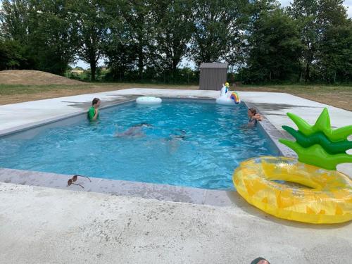 un groupe d'enfants jouant dans une piscine dans l'établissement Elegant and Spacious Maison de Maitre Ideal for Group Bookings, à Samadet
